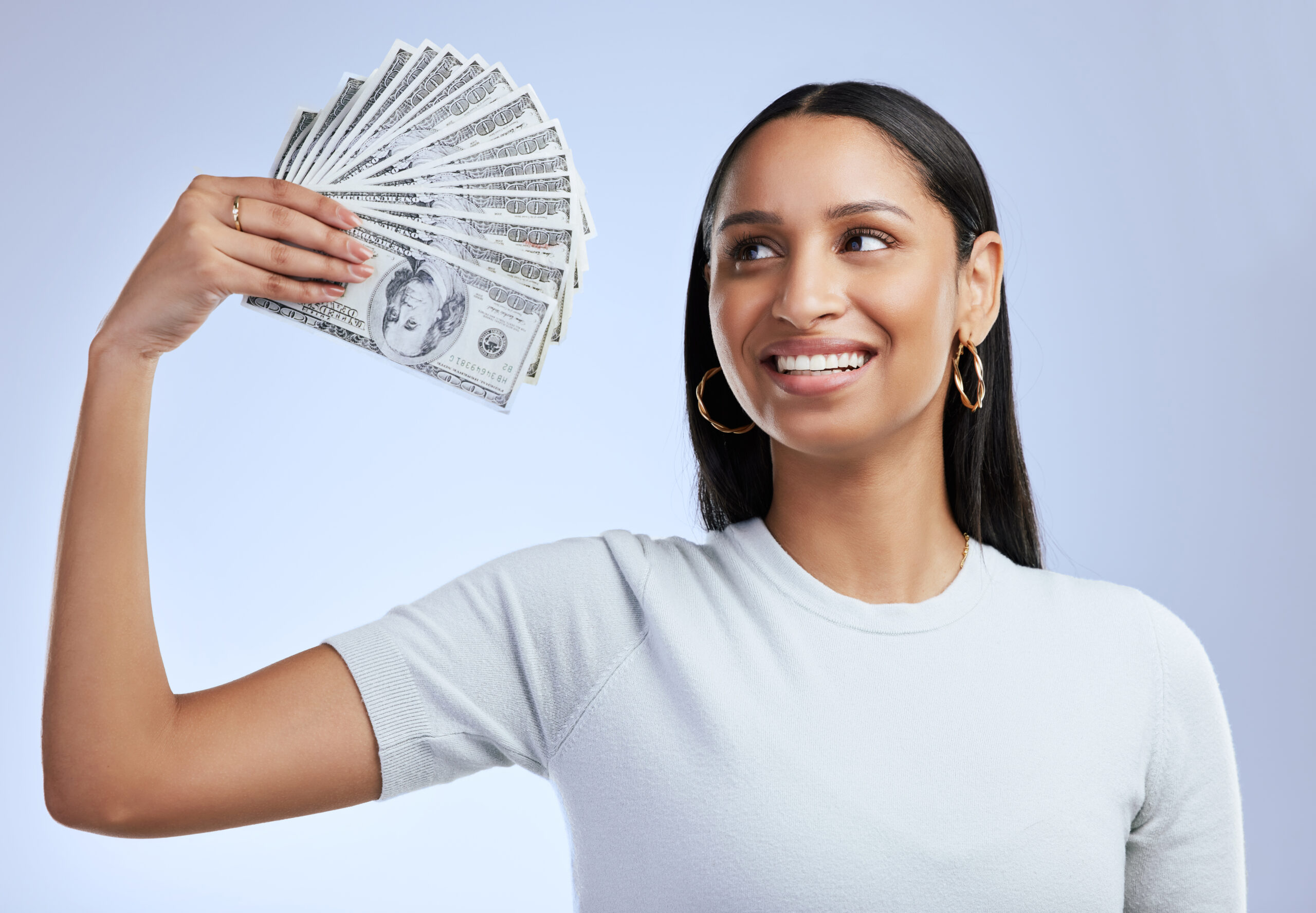 shot of a young woman holding up bank notes agains 2023 11 27 05 10 07 utc scaled